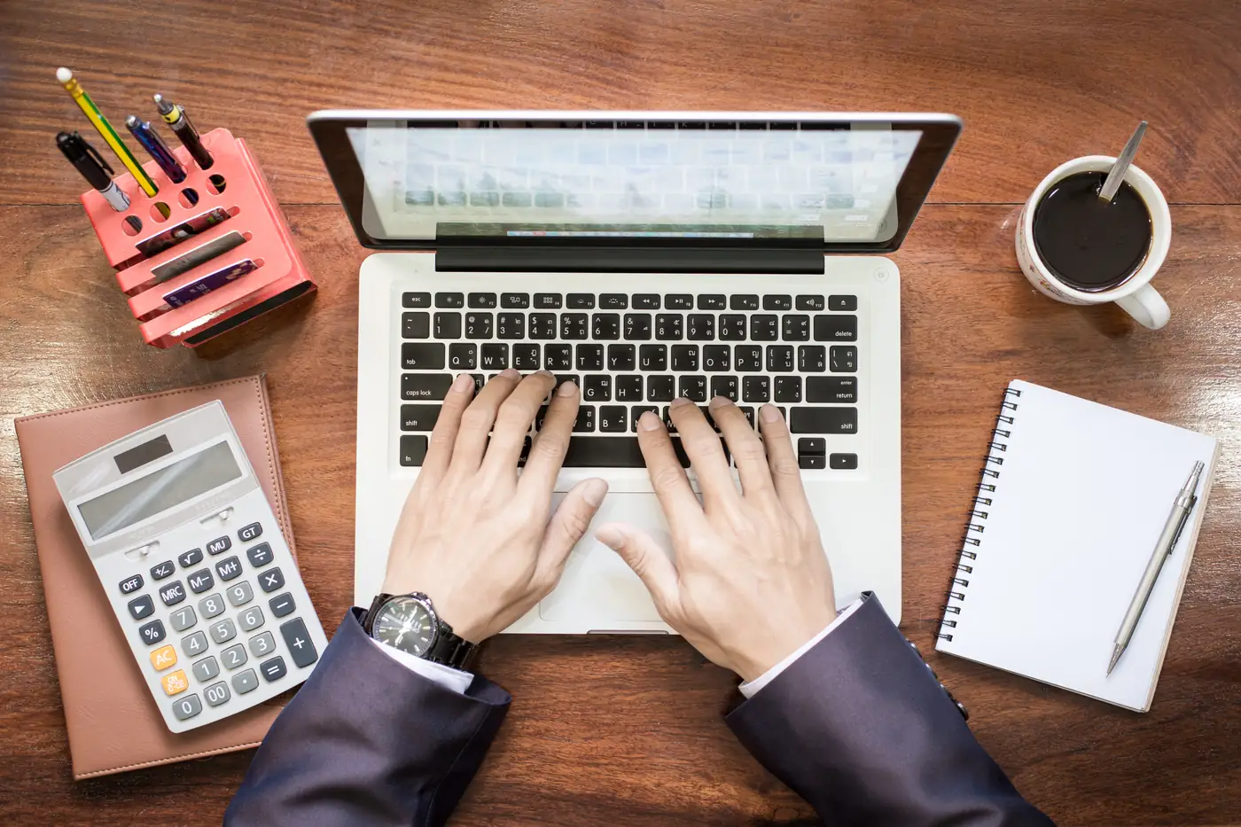 Calculator, laptop and budget notes on a desk