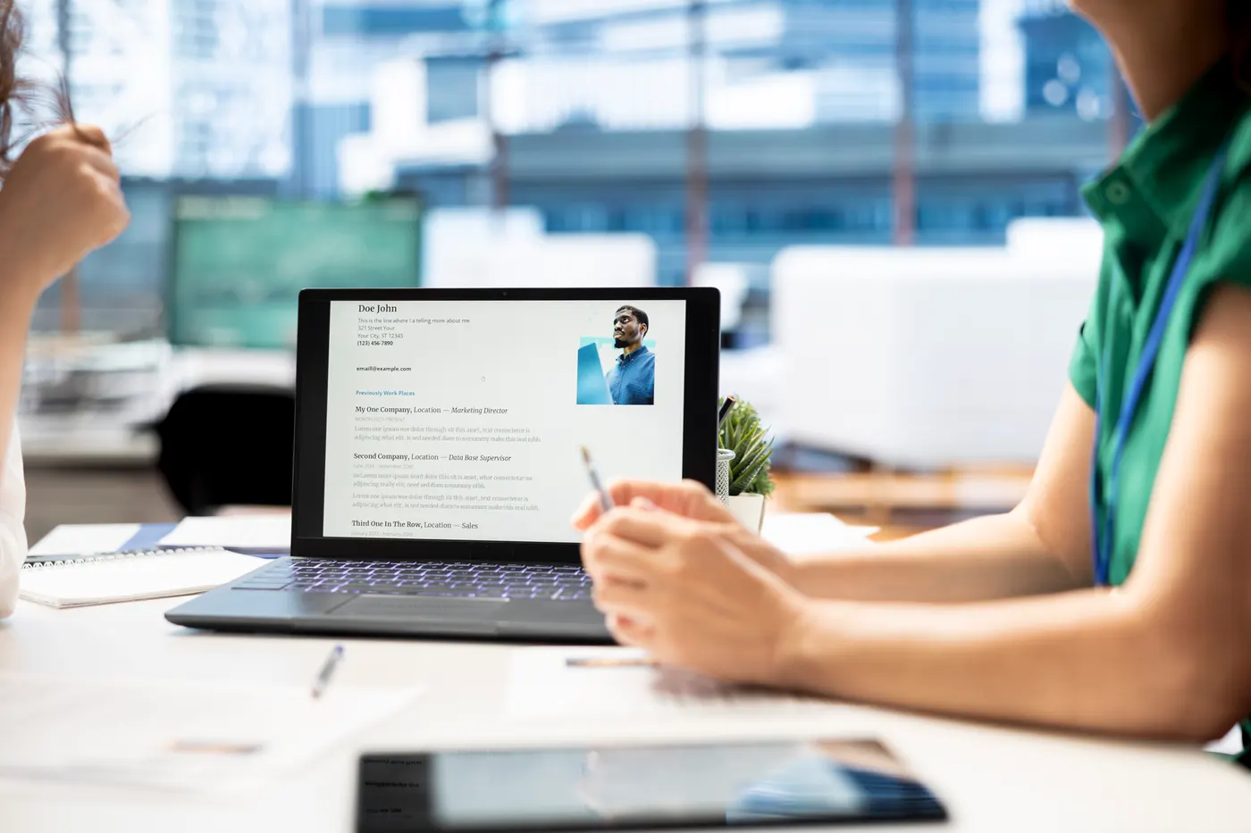 HR desk with a notebook and a candidate profile open on a laptop